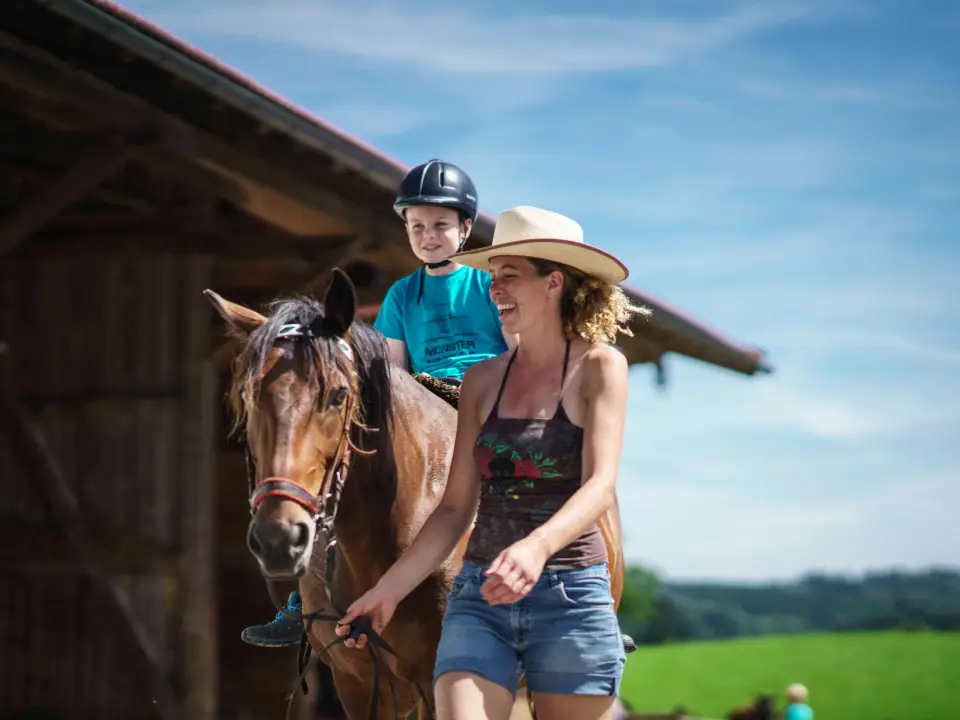 Kind wird auf einem Pony über den Hof Gottenau geführt