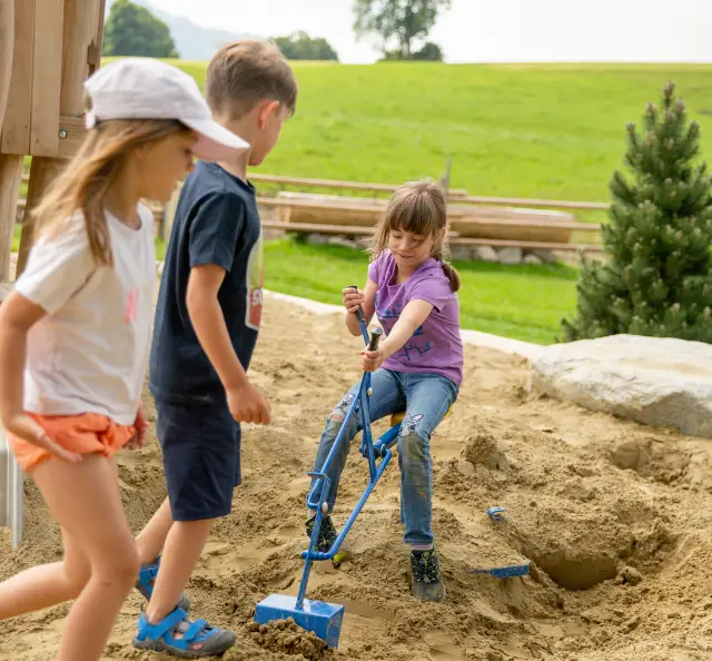 Kinder buddeln mit Schaufeln im großen Sandkasten vom Hof Gottenau