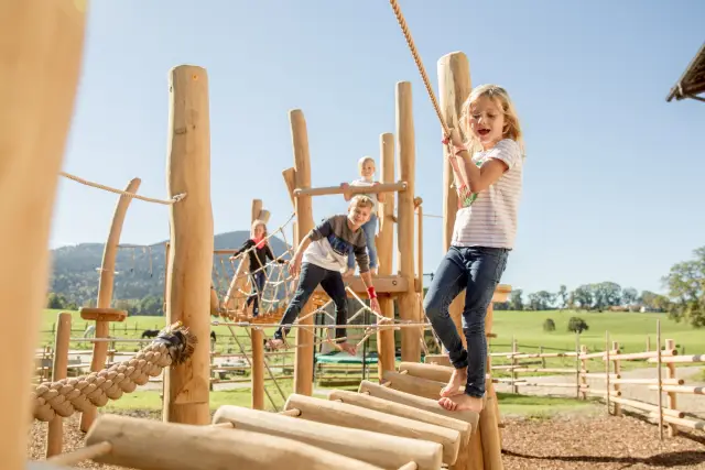 Kinder klettern am Spielturm aus Robinienholz auf dem Hof Gottenau