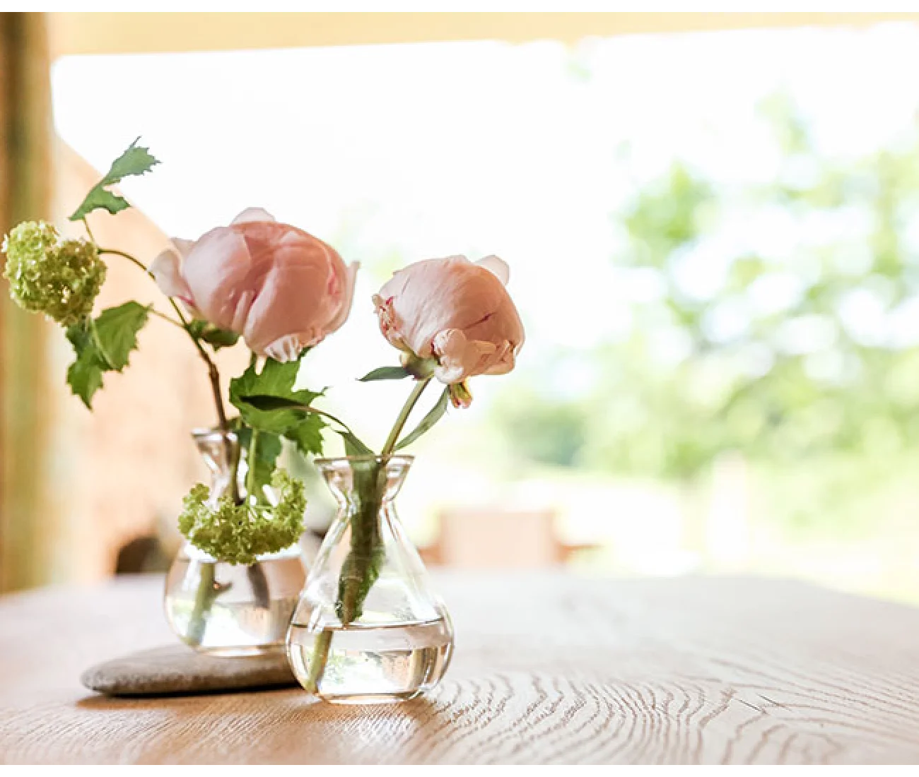 Blumenvase mit rosa Rosen auf Holzoberfläche	