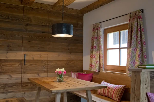 Gemütliche Eckbank mit Altholzwand in der Almhütte	
